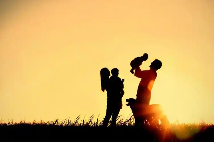 一个幸福的家庭四口人母亲父亲宝贝和孩子和他们的狗在夕阳的天空副本