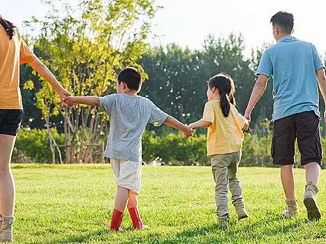 快乐的四口之家在公园散步