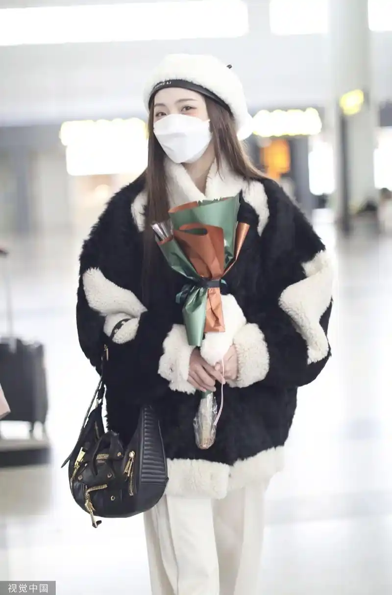 组图:郑乃馨戴白色贝雷帽现身机场 手捧粉丝赠送花束笑眼弯弯