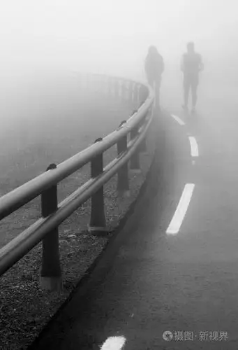 夫妻沿着道路在雾中散步