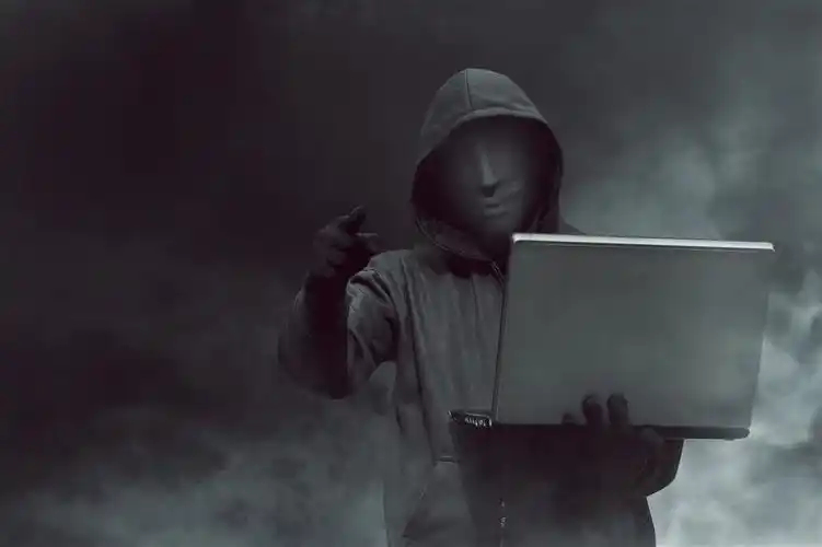 乌云笼罩的天空下拿着电脑的黑客高清图片