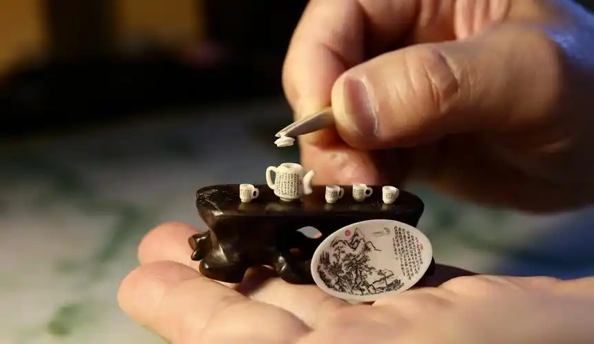 代表性传承人王天明展示自己创作的包含300字的微雕作品《三绝酒具》