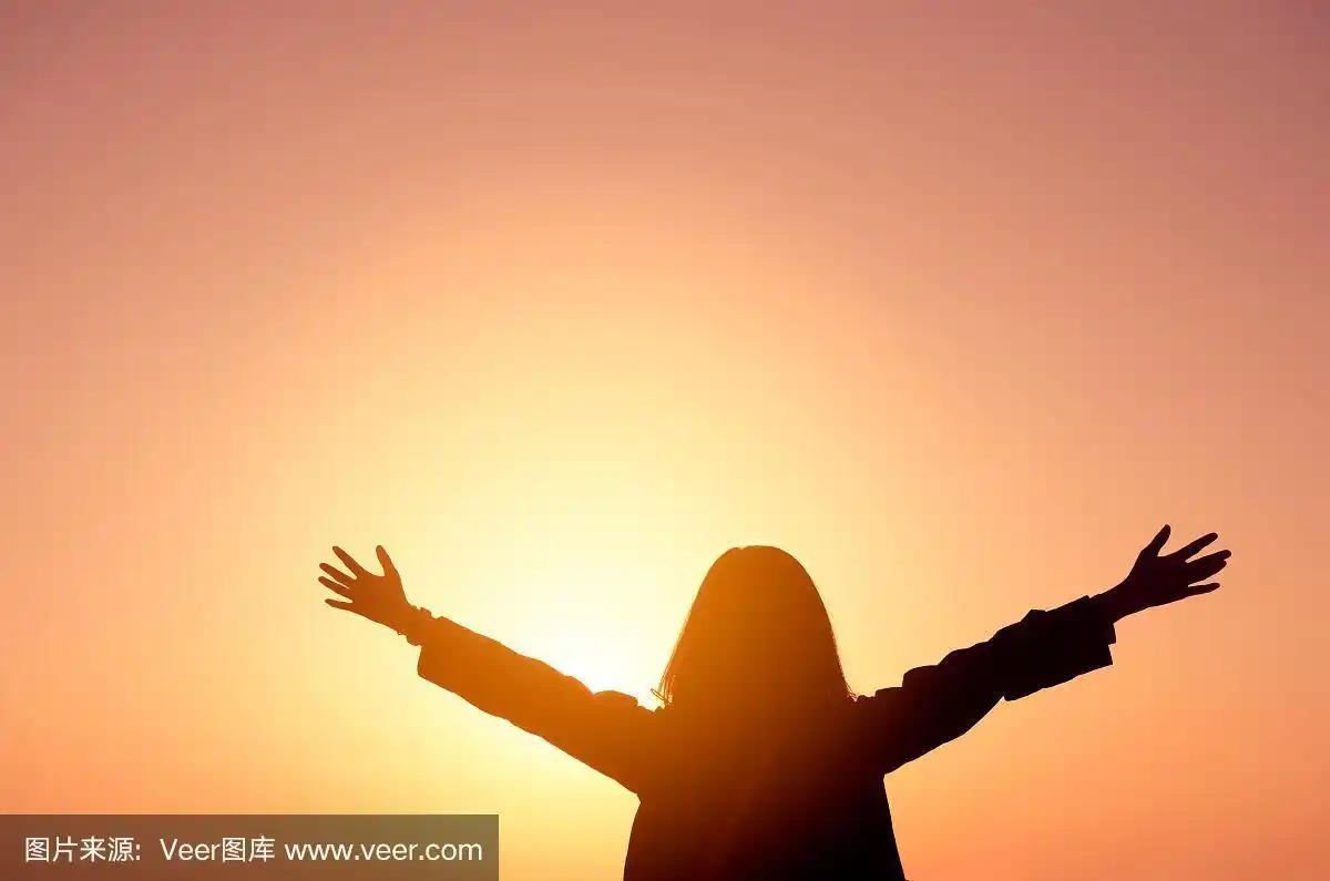 复制空间的剪影女子举起的手在日落天空的背景.