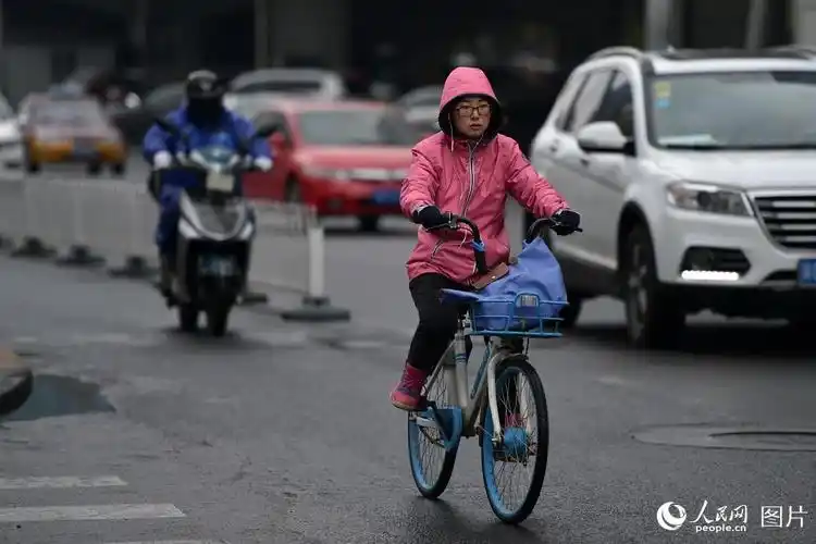 北京城区降温又降雨 路上行人瑟瑟发抖
