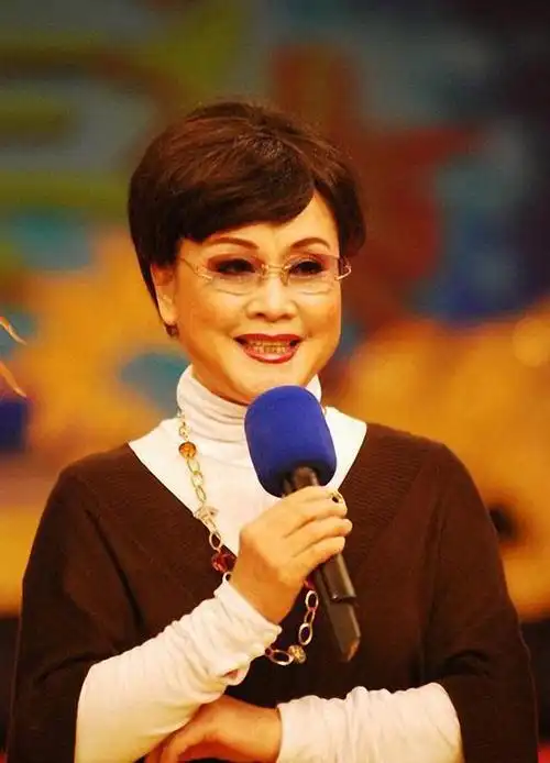 76岁李谷一走机场,穿大花袄踩高跟靴,素颜出镜依然美出新高度