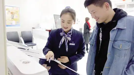 陇南分行大堂经理正在用智慧柜员机指导客户申请信用卡.