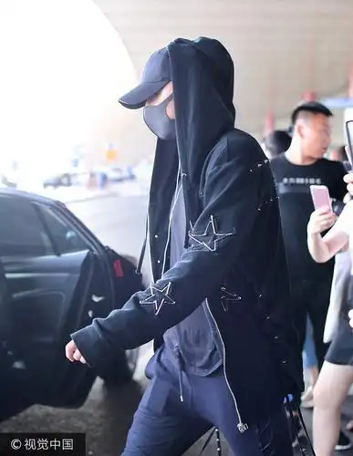 黄子韬抵京机场被数十迷妹"逼至角落" 戴"巫师帽"衣衫大敞似伏地魔