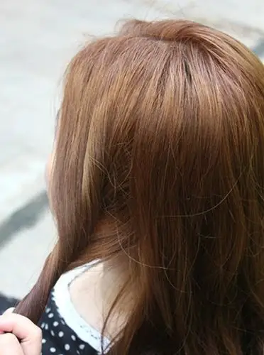 在头发左侧分一缕头发.