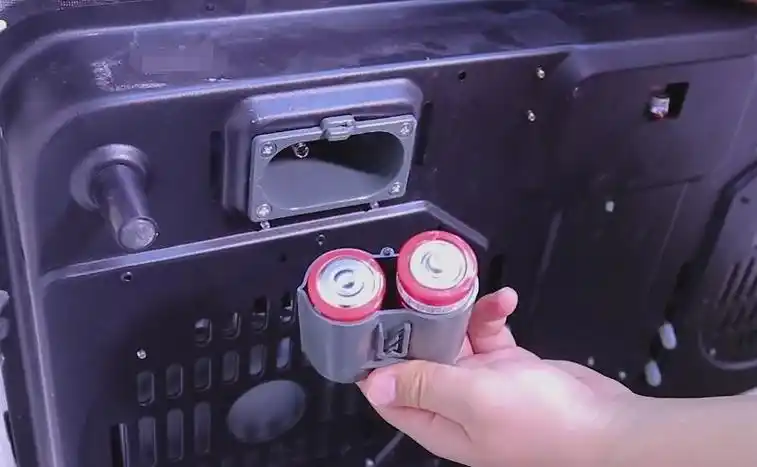 托起燃气灶后就可以看到电池位置,打开它抠出电池,及时更换新电池就