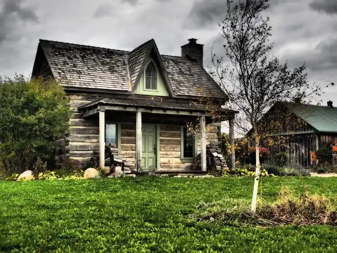 灰色和棕色木房子附近绿草在多云的天空高清壁纸