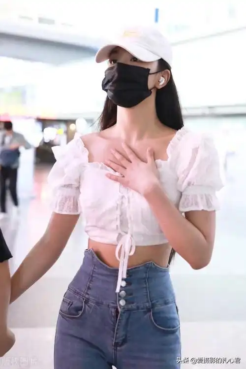 时尚街拍孔雪儿白色泡泡袖露脐上衣蓝色牛仔喇叭裤运动鞋