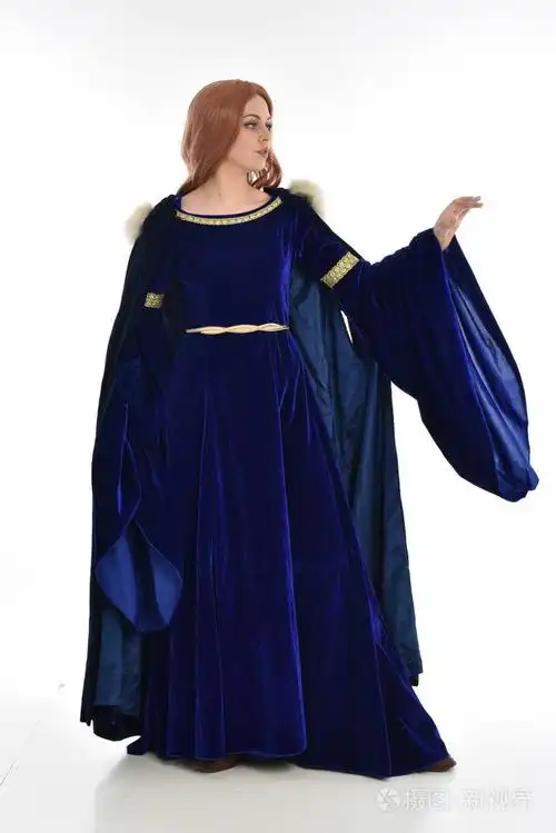 长发女人的全长肖像穿着蓝色天鹅绒中世纪长袍和毛皮斗篷站立姿势孤立